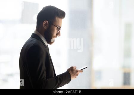 Young Arabic businessman using smartphone checking mail Stock Photo