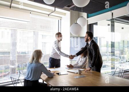 Multiracial male business partners handshake greeting at meeting Stock Photo