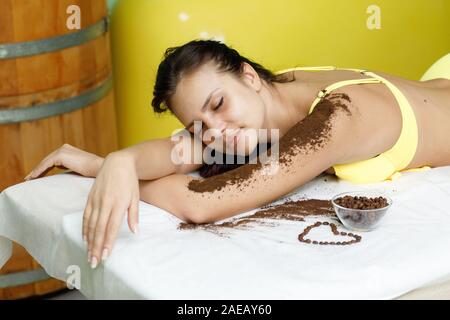 Woman brunette getting coffee scrub treatment in beauty or spa salon Stock Photo