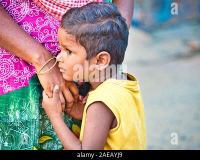 PUDUCHERRY, INDIA - DECEMBER Circa, 2018. Unidentified shy embarassed son standing close his mother in the street of a dalit village Stock Photo