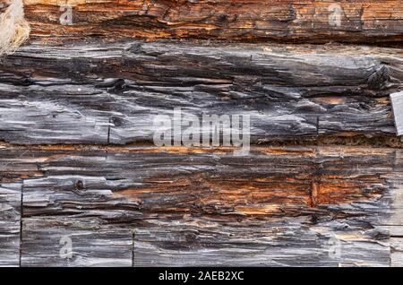Old log wall. Texture of the wooden wall of an old house. Close up. Stock Photo