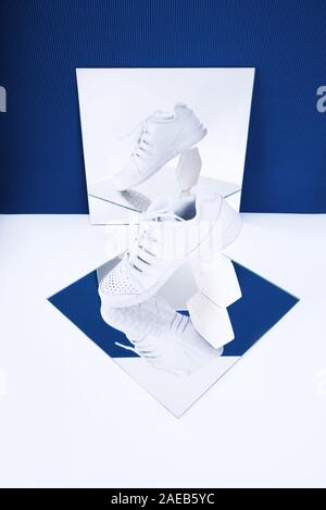 Pair of white sneakers on trendy blue and white background. Stock Photo
