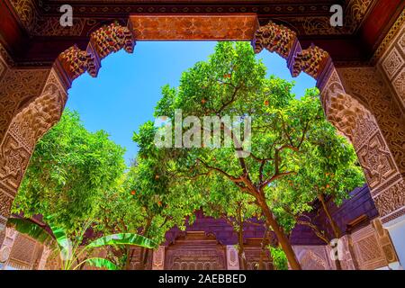 One of the big ornamental gates of El Bahia Palace and an orange tree in Marrakesh old town.Morocco. Stock Photo