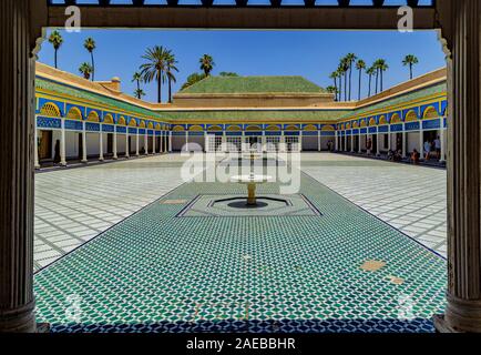Courtyard at El Bahia Palace in Marrakech.The palace is richly decorated throughout;colored tiles, green ceramic roofs, bright yellow and blue arches Stock Photo