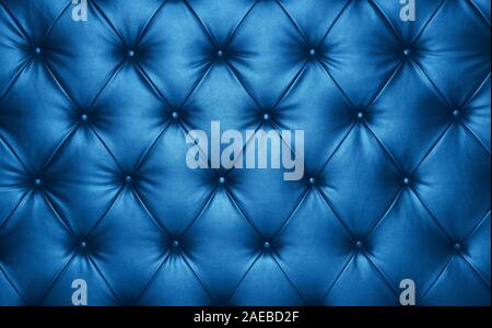 Close up background texture of dark blue capitone genuine leather, classic retro Chesterfield style soft tufted furniture upholstery with deep diamond Stock Photo