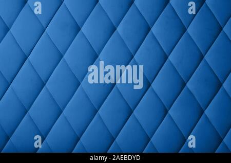 Close up background texture of dark blue genuine leather soft tufted furniture or classic wall panel upholstery with deep diamond pattern Stock Photo
