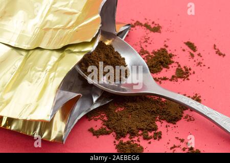 Ground coffee spilled from the packaging. Grinded coffee powder in measuring scoop. Open coffee vacuum foil bag. Stock Photo