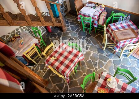 Above view of table with yellow and green chairs on stone made floor Stock Photo