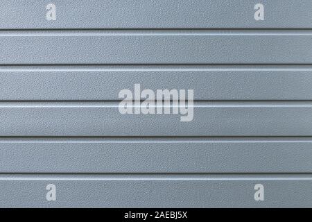 Striped gray metal surface. Texture of grey ribbed metallic cladding. Convex wall background with lines. Modern pattern of metal fence Stock Photo