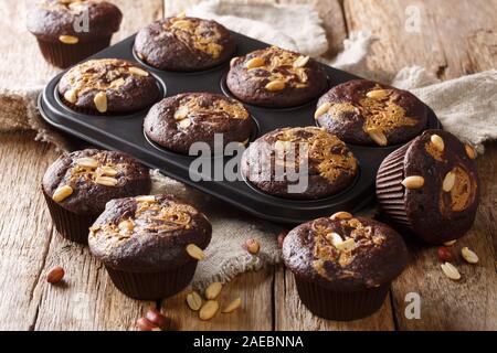 delicious breakfast of chocolate muffins with peanut butter and nuts in a baking dish on the table. horizontal Stock Photo