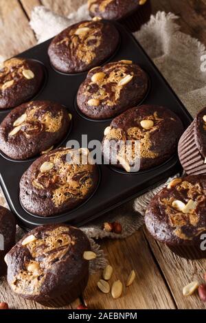 Chocolate peanut muffins in a baking dish on the table. vertical Stock Photo