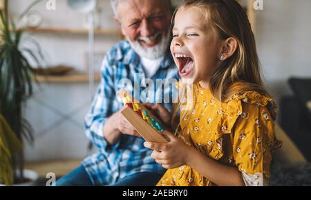 Grandfather and child playing together at home. Happiness, family, relathionship, learning concept.