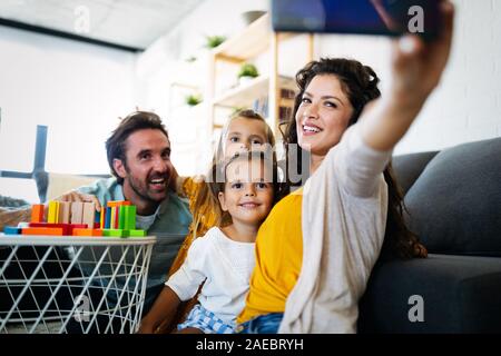 Happy young family take a self portrait with smart phone. Stock Photo