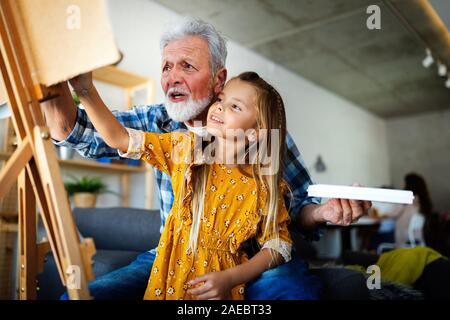 Senior man, grandfather and his grandchild drawing, painting together. Happy family time Stock Photo