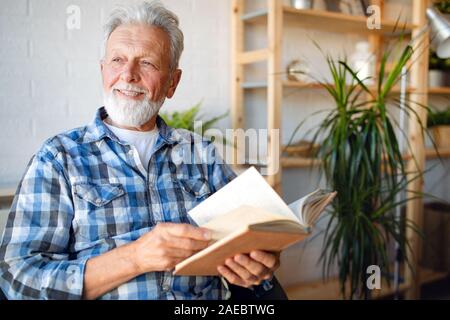 Senior man at home reading book and enjoying retirement, penison Stock Photo