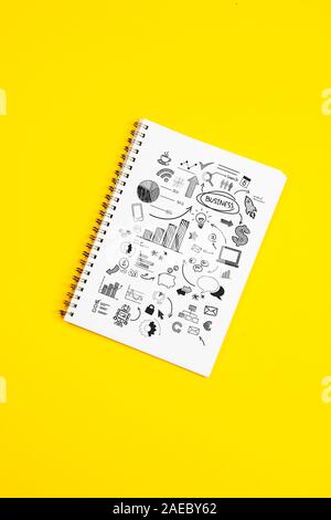 White paper page with doodles and business strategies on a yellow background Stock Photo