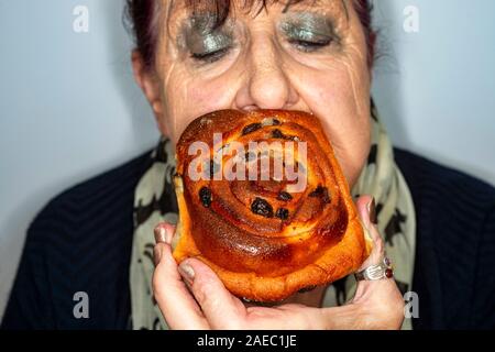 Woman eating a Chelsea bun cake Stock Photo