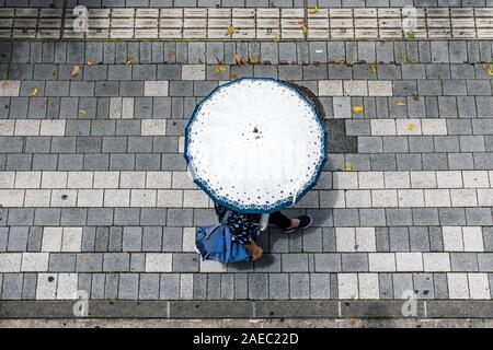 Woman walking with parasol, seen from above Stock Photo