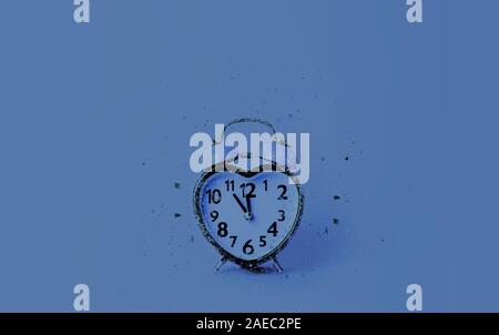 Heart shaped clock on blue background. Stock Photo