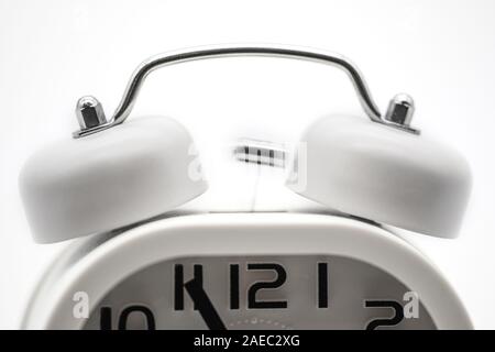 Upper view of a white ringing alarm clock isolated on white background Stock Photo