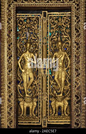 Gilded wooded door panels in bas-releif depicting Rama fighting mythical lions, Temple Wat Pa Phai, Luang Prabang, Laos Stock Photo