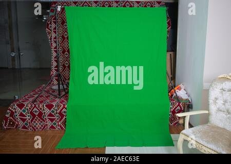 Big green background for added special effects in post production.Green screen. The chroma key. green screen chroma key background on commercial set. Stock Photo