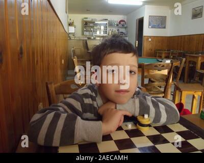 Boy in a traditional greek kafenion Crete, Greece. Stock Photo