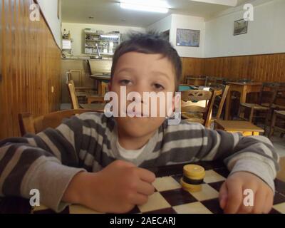 Boy in a traditional greek kafenion Crete, Greece. Stock Photo