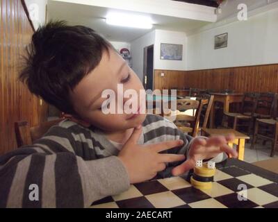 Boy in a traditional greek kafenion Crete, Greece. Stock Photo