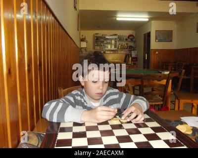 Boy in a traditional greek kafenion Crete, Greece. Stock Photo