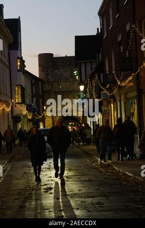 Shoppers walking down a medieval street lined with Christmas lights, High Petergate ,York, North Yorkshire, England, UK. Stock Photo