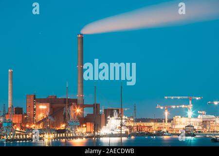 Helsinki, Finland - December 10, 2016: Evening Night View Of Industrial Zone Of Hanasaari Power Plant And Pier, Berth With Moored Ships, Vessels. Nigh Stock Photo