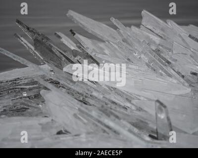 Clear ice washed up on the river shore like shards of glass Stock Photo