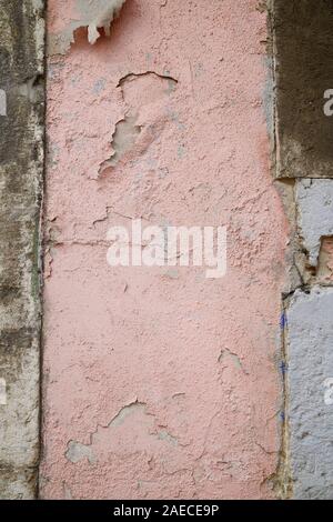 Close-up of a weathered and old concrete wall, pink paint is peeling off. High resolution abstract full frame textured background. Stock Photo