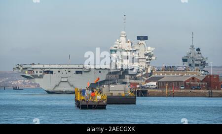 The Royal Navy aircraft carrier HMS Prince of Wales (R09) will be formally accepted into service with a Commissioning Ceremony at Portsmouth Naval Base, UK on the 10th December 2019. The ceremony will be attended by HRH The Prince of Wales and HRH The Duchess of Cornwall as the ship's sponsor. The ship is seen here on the 4th December 2019 alongside at the Naval Base with HMS Queen Elizabeth in the background. Stock Photo