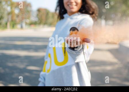 the girl has colored smoke streaming from her pocket watch in her hand. portable time value dust smoke water Stock Photo