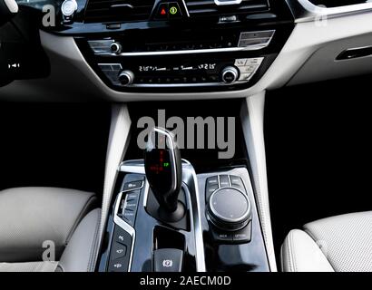 Automatic gear stick of a modern car. Modern car interior details. Close up view. Car detailing. Automatic transmission lever shift. White leather int Stock Photo