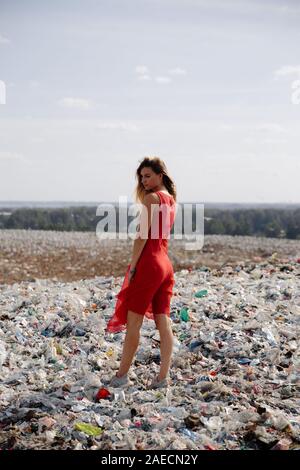 Nature pollution activist at a huge trash dump outdoors - Young blonde ...