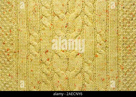 Texture of Wool Knit Color of Mustard Fabric Interspersed with Red Orange Yarn. Sweater Background Close-Up View Stock Photo