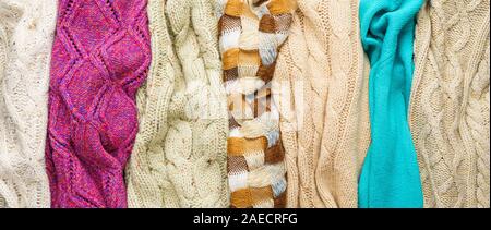 Several Different Colorful Knitted Sweaters Lays Side by Side as Background Stock Photo