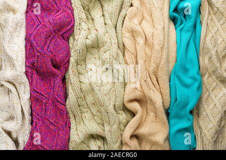 Several Different Colorful Knitted Sweaters Lays Side by Side as Background Stock Photo