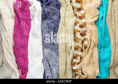 Several Different Colorful Knitted Sweaters Lays Side by Side as Background Stock Photo
