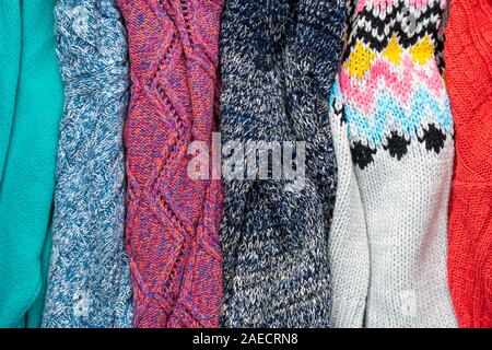 Several Different Colorful Knitted Sweaters Lays Side by Side as Background Stock Photo