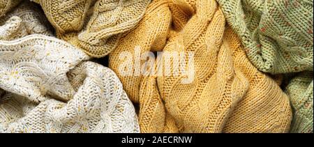 Pile of Knitted Winter Sweaters. Piles of clothes background Stock Photo