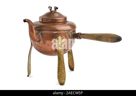 Vintage rustic copper tea kettle with handle and legs isolated on white background. Stock Photo