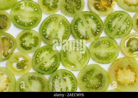 Sliced green tomatoes on white background. Pattern. Still life Stock Photo