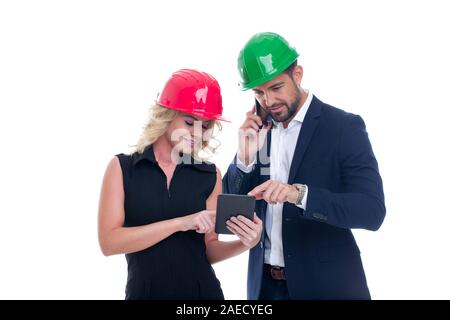 Young engineers with mobile communication devices, boss calling, co-worker showing data on tablet, isolated on white Stock Photo