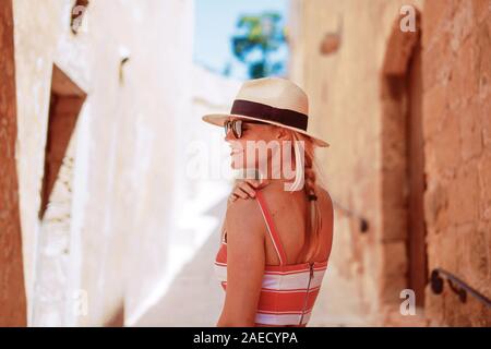 Young romantic traveler positive woman in hat on Mediterranean street Stock Photo
