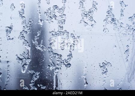 glass in the window covered with wet melting snow, close-up, macro Stock Photo