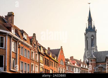 Tall medieval bell tower rising over the street with old european houses, Tournai, Walloon municipality, Belgium Stock Photo